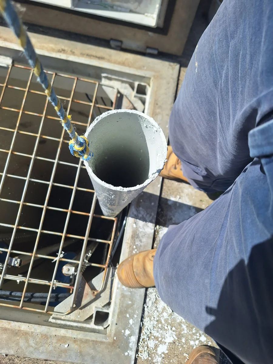 Sampling container beside a grated access opening during field work